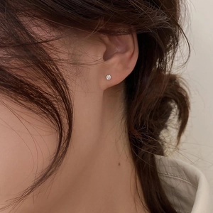 Détail d'une boucle d'oreille en argent s925 avec zircon rond et serti à quatre griffes