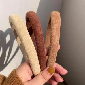 Close-up of three soft suede headbands in beige and brown for autumn style
