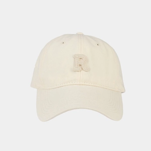 Dettaglio cappello beige con ricamo a rilievo della lettera R e trama in cotone naturale