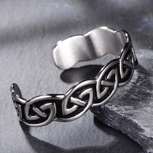 Macro detail of vintage Celtic knot engraving on silver stainless steel Viking cuff bracelet