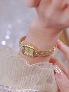 Close-up of luxury gold square watch for women featuring diamond-set bezel and mesh strap