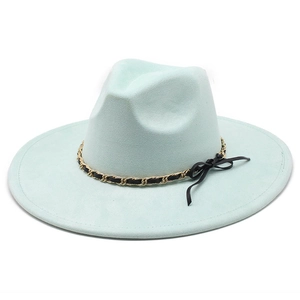 Detail of mint green fedora hat featuring gold chain trim and a black bow accent