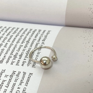 Close-up of minimalist S925 silver ring with double metal beads on an open book