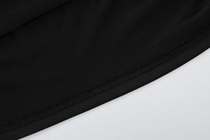 Close-up of black fabric texture with detailed overlock stitching on summer t-shirt