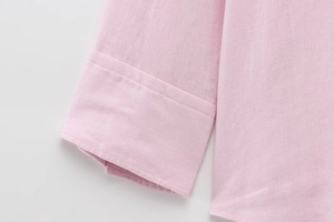 Close-up of pink long-sleeved shirt cuff showing cotton linen texture and stitching