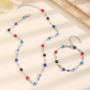 Detail of silver Evil Eye necklace and bracelet set with red and blue charms
