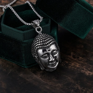 Ethnic Buddha head pendant in silver stainless steel on green velvet jewelry box