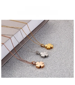 Dettaglio dei ciondoli a quadrifoglio a forma di cuore in oro, argento e acciaio inossidabile