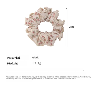 Detailed fabric scrunchie view showing red floral pattern, 12cm diameter and 13.3g weight