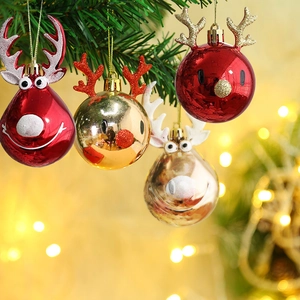 Close-up of red and gold Christmas reindeer ornaments with glitter on tree branches