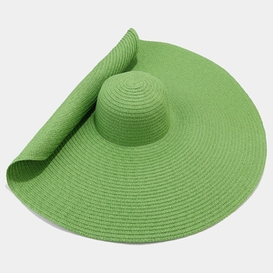 Dettaglio del grande cappello di paglia verde con tesa larga e trama a spirale