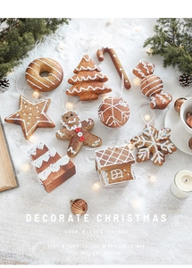 Flat lay of gingerbread man and star ornaments on white snow with festive decorations