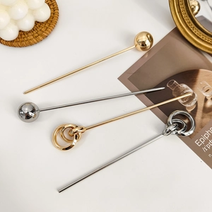 Detailed view of modern geometric hair pins in gold and silver finish with sphere design