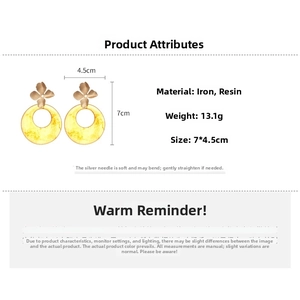 Detail view of yellow resin hoop earrings with gold metal flower studs and sizing info