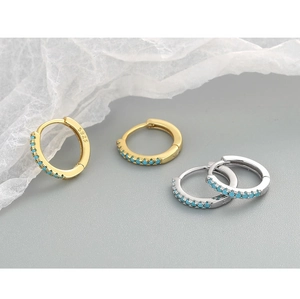 Detail of S925 hallmark on gold and silver hoop earrings with turquoise stones
