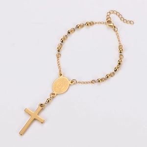 Detailed view of golden rosary bracelet with cross and Virgin Mary medal pendant