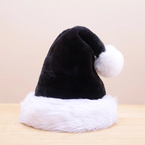 Detailed view of a soft black and white plush Christmas hat on a wooden surface