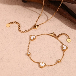 Detail of 18K gold-plated necklace and bracelet set with white heart shell and zircons
