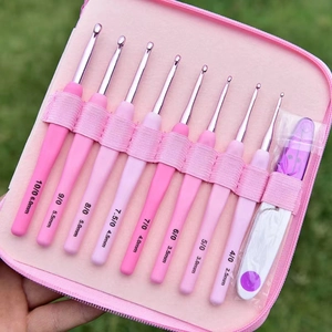 Pink soft grip crochet hook set with 8 sizes in a zipper case shown in hand outdoors
