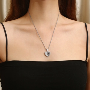 Vue détaillée du collier pendentif cœur asymétrique avec motif évidé et cristaux