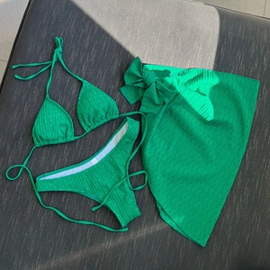 Detailed macro shot of bright green polka dot bikini fabric and size label S on gray