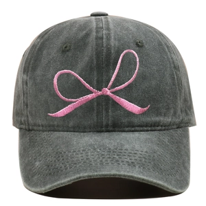 Detail der rosa Schleifenbestickung auf einer dunkelgrau gewaschenen Baseballkappe
