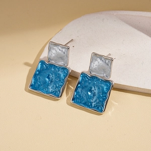Detail of blue enamel inlay and hammered silver texture on geometric square earrings