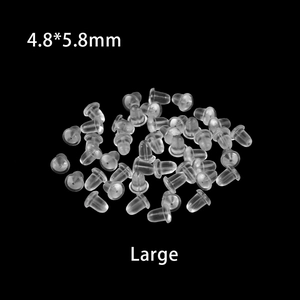 Macro view of large 4.8x5.8mm transparent silicone earring backs on black background