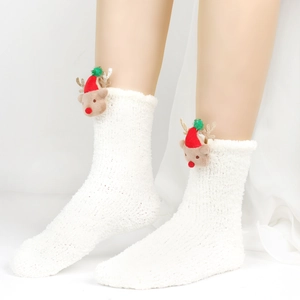 Nahaufnahme weißer Flauschsocken mit 3D-Weihnachtsrentier und goldenen Glitzergeweihen