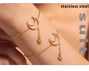 Macro shot of 18K gold plated stainless steel star and moon charm bracelet set
