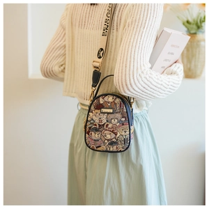 Detail of a tapestry crossbody bag with teddy bear pattern and BEIBEI fabric strap