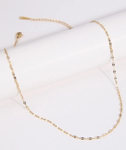 Detail of gold metal link chain necklace with lobster clasp on white display stand