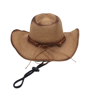 Détail d'un chapeau de cowboy en paille marron foncé avec bande en cuir et mentonnière réglable