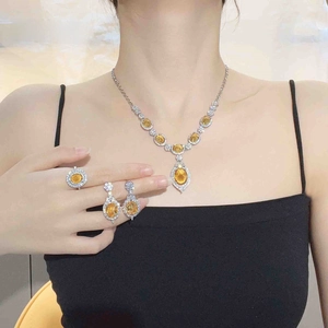 Detailed view of luxury silver jewelry set with oval yellow stones and white zircons