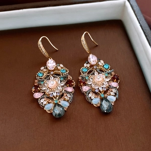 Detail of vintage bohemian drop earrings with pink crystals and teardrop pendants