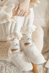 Close-up of white coral fleece cat socks and slippers for warm home wear