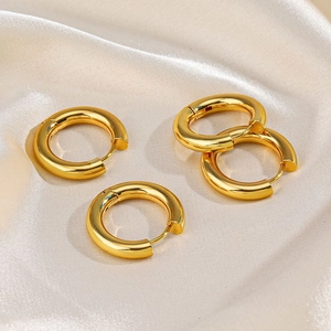Two pairs of chunky 18K gold plated stainless steel hoop earrings on silk fabric