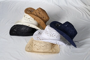 Close-up of six-color stackable hollow out crochet cowboy straw hats on white fabric