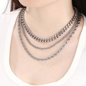 Close-up of layered silver stainless steel chains featuring Cuban and rope link textures