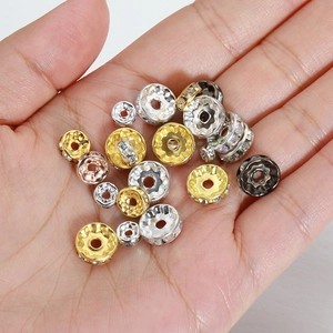 Assorted rhinestone spacer beads in gold and silver held in hand for DIY jewelry making