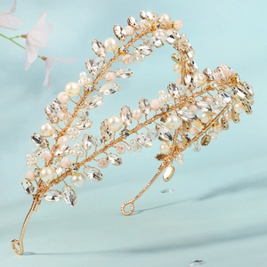 Detailed macro view of handmade crystal leaves and pearls on a gold bridal headband