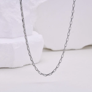 Macro detail of silver stainless steel box chain link with minimalist industrial style