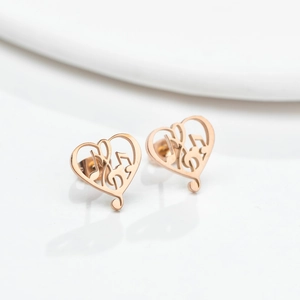 Macro view of rose gold heart-shaped earrings with a music note hollow design
