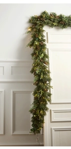 Macro detail of Christmas garland with pine cones, eucalyptus leaves and warm LED lights