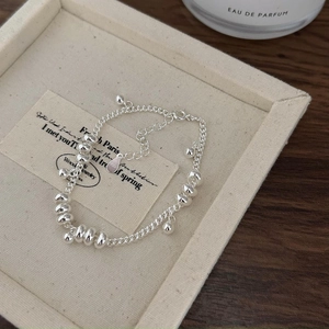 Minimalist 925 sterling silver beaded bracelet with round charms on a textured tray