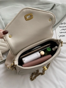 Quilted crossbody bag with gold chain showing internal storage for phone and makeup