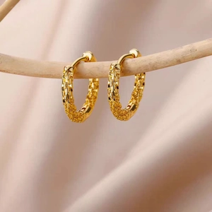 18K gold hoop earrings with textured checkered weave design on elegant silk background