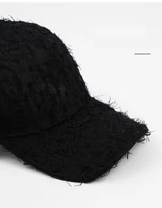 Close-up of black baseball cap featuring frayed edge distressing and wide brim detail