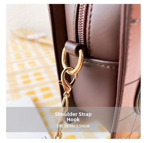 Macro shot of durable gold-tone metal lobster clasp and brown leather bag stitching details
