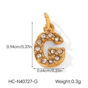 Vue détaillée du pendentif lettre G en acier doré serti de petits strass brillants